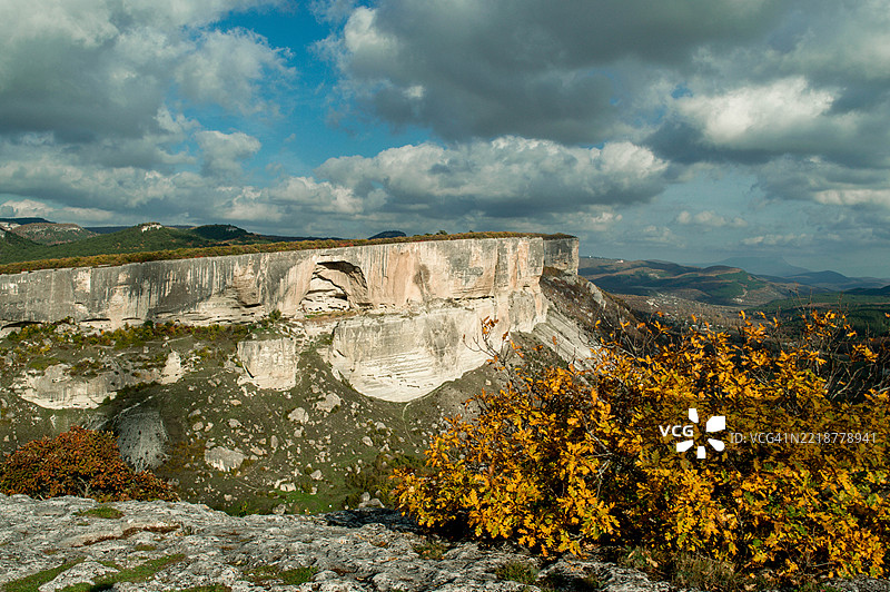 高山背景下的美丽秋日树木。图片素材