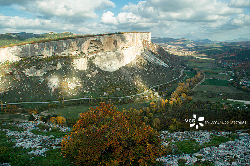 高山背景下美丽的秋天树木。图片素材