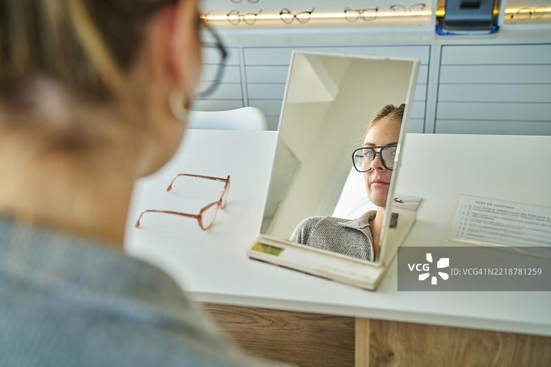 迷人的女士在零售店挑选时尚眼镜图片素材