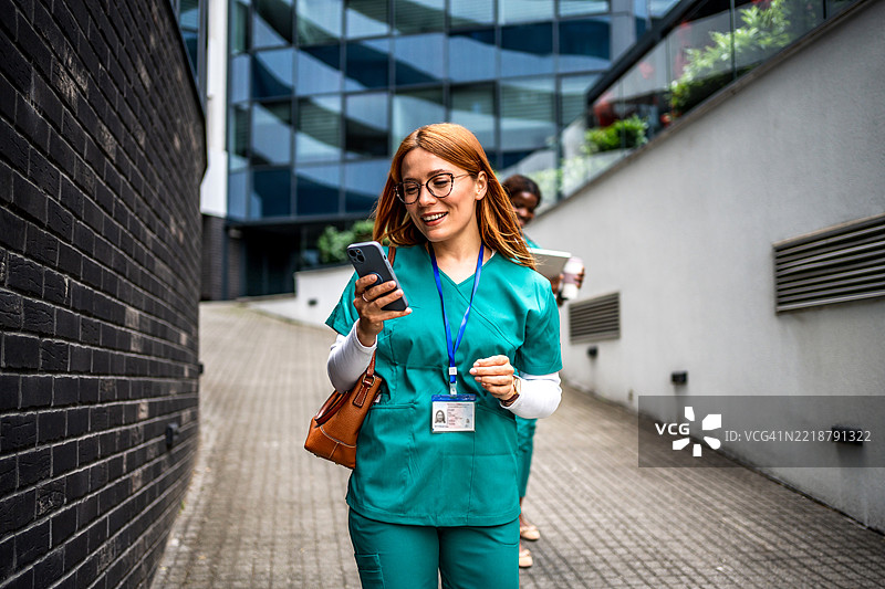 护士在医院附近走动并使用智能手机图片素材
