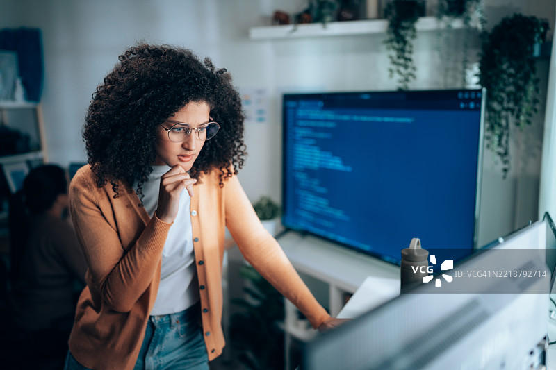 女性软件工程师在笔记本工作站分析程序代码图片素材