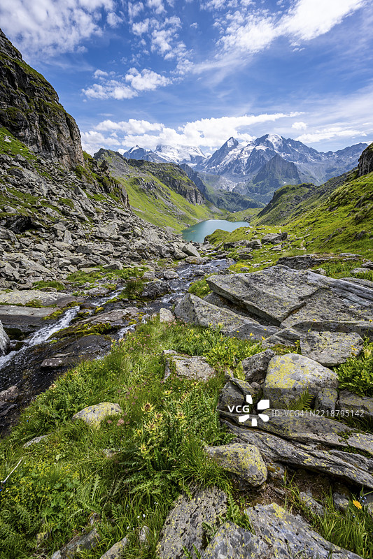 风景如画的山地景观中的山溪,远眺卢维湖和格朗德·孔比纳冰川山峰,瓦莱阿尔卑斯,巴涅谷,瓦莱州,瑞士,欧洲图片素材