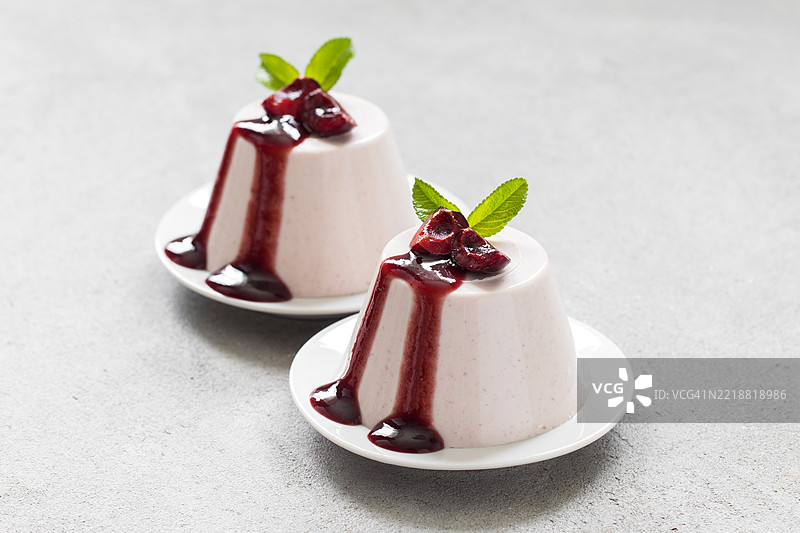意大利甜点。樱桃奶油布丁，意式奶冻。配樱桃酱。放在盘子上。图片素材