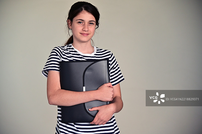 自信快乐的少女手持文件夹图片素材