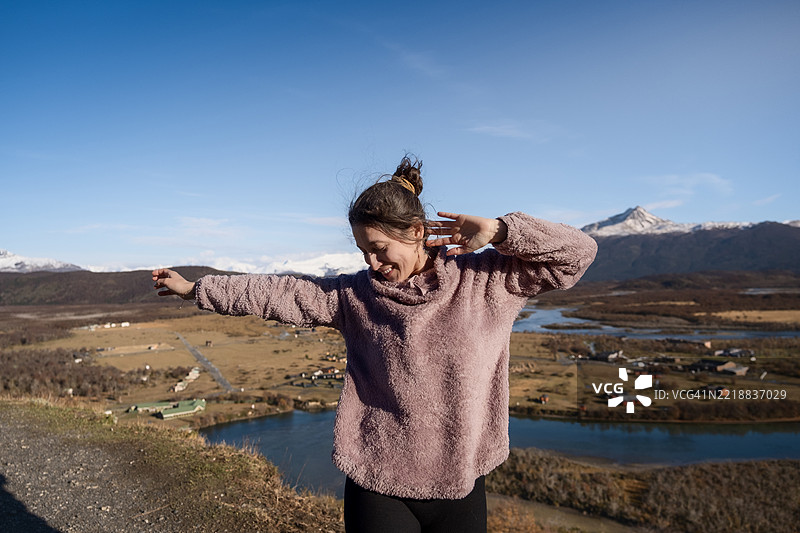 年轻女性在阿根廷埃尔查尔滕的美丽山景中跳舞图片素材