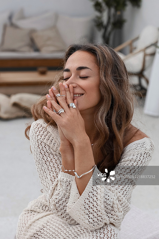 微笑的女性，佩戴时尚的银色珠宝和钩针编织裙子图片素材