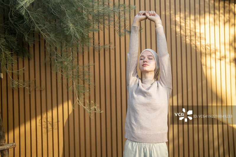 年轻的癌症患者在木墙前伸展双臂图片素材