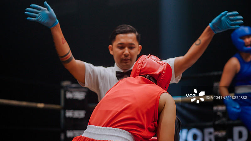 年轻的亚洲裁判在为被击倒的拳击手数到十时宣布比赛结束。图片素材