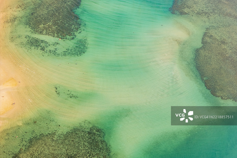 清澈的水流轻柔地流过沙底图片素材