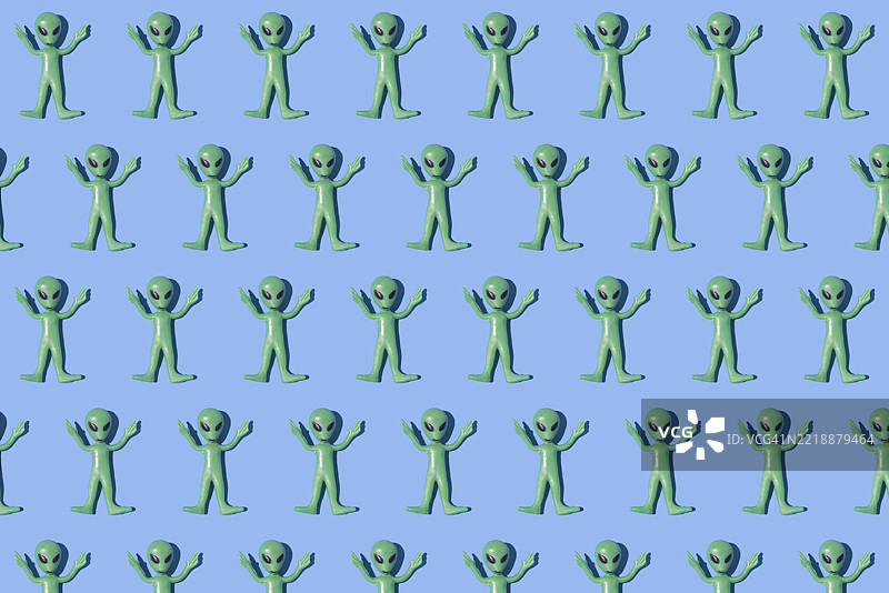 绿色外星人玩具图案，背景为纯蓝色。外星人，虚构，科幻，恐怖，罗斯威尔，51区，外星学，飞碟。图片素材