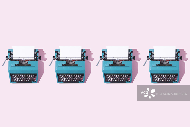 绿色复古打字机的图案，排列在粉色背景上，旁边有一张空白纸。编剧、作家、写作、新闻、文学与文化。图片素材