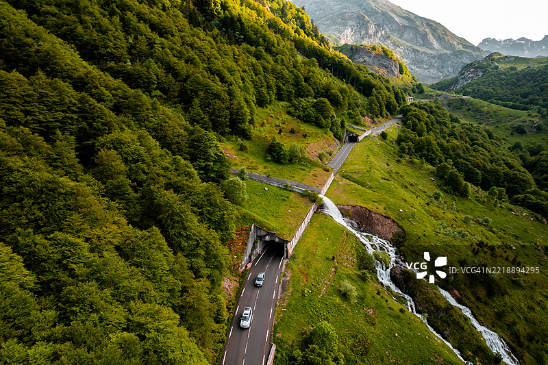 壮观瀑布的鸟瞰图，自然的力量穿越法国比利牛斯山脉的绿色山路隧道系统 - 绿色基础设施促进清洁出行图片素材