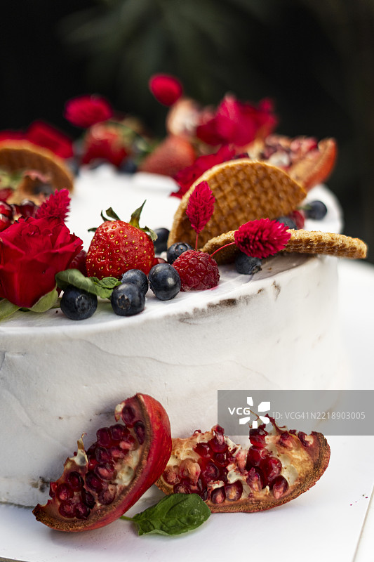 小型婚礼蛋糕装饰着新鲜草莓、石榴和花朵图片素材