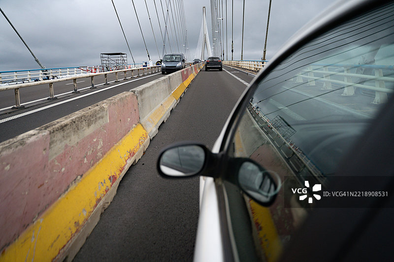 汽车在法国诺曼底大桥上行驶，背景是戏剧性的多云天空图片素材