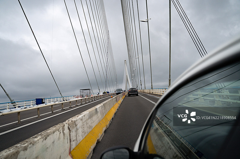 汽车在法国诺曼底大桥上行驶，背景是戏剧性的多云天空图片素材
