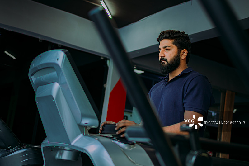 专注的印度男子在跑步机上行走 - 健身与心理健康图片素材