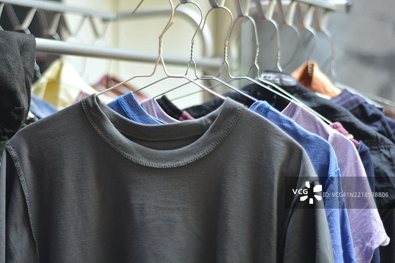 五颜六色的衬衫和裤子挂在晾衣架上晾干图片素材