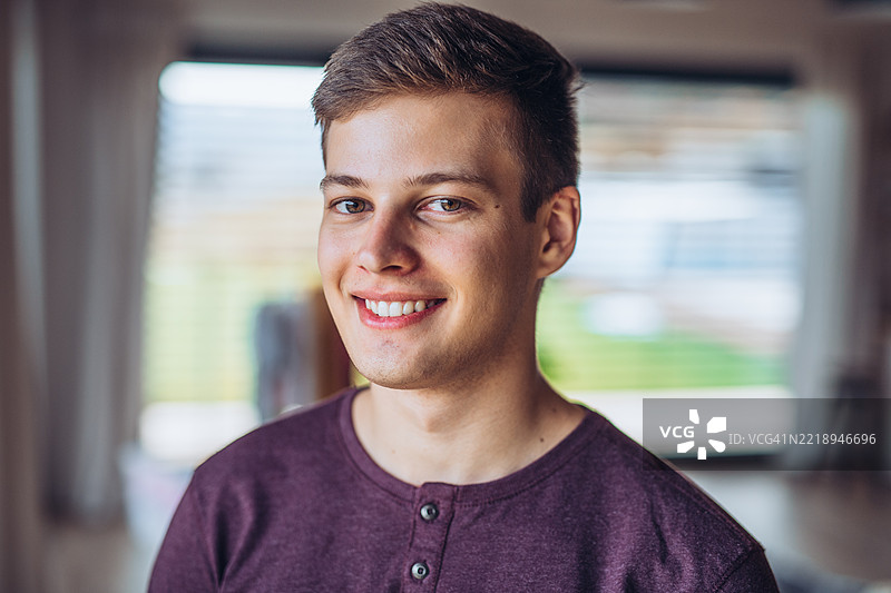 年轻男子微笑着看向镜头。图片素材