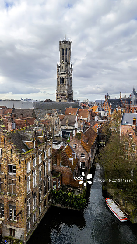 布鲁日蜿蜒运河的鸟瞰图，历史悠久的弗拉芒房屋与红色屋顶和阶梯式山墙沿着宁静的鹅卵石街道排列，联合国教科文组织列入的中世纪城市，旅行与建筑遗产概念图片素材