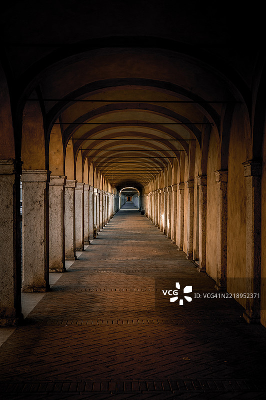 阴暗隧道透视，磨损的建筑，阴影中的老走廊图片素材
