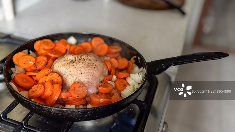 铸铁煎锅中的胡萝卜洋葱炒鸡肉图片素材