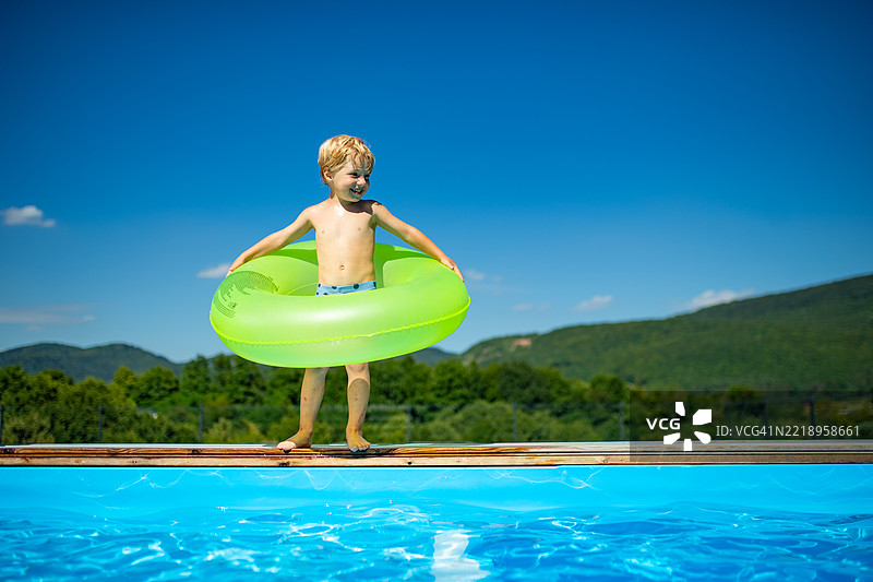 孩子在游泳池旁享受阳光明媚的夏日。图片素材