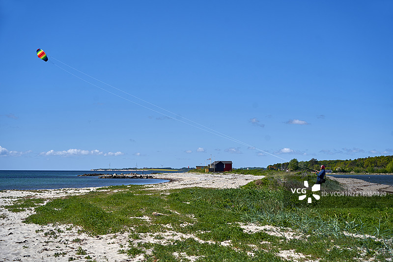 一位女性在波罗的海的厄尔岛马尔斯塔尔海滩上操控特技风筝图片素材