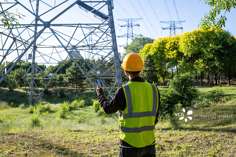 电工站在输电塔下图片素材