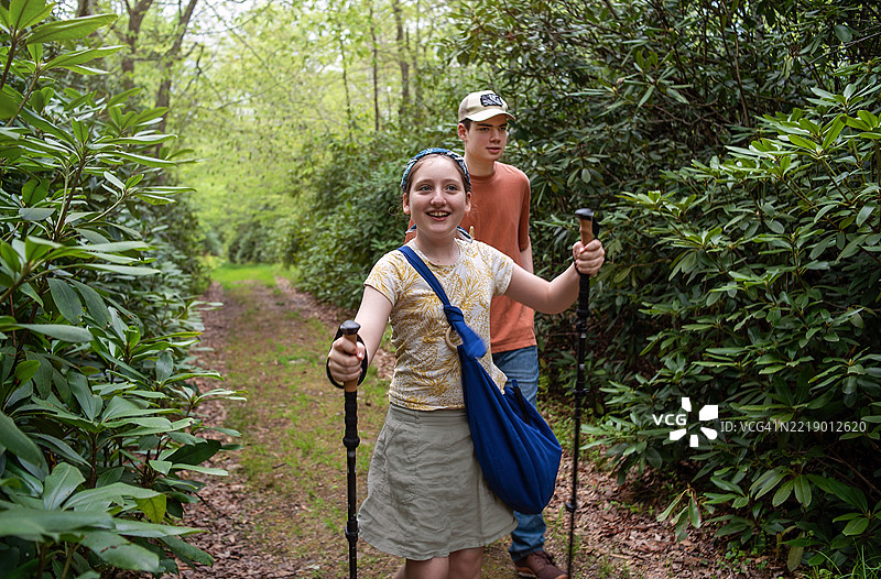 兄弟姐妹在春季徒步小径上一起探索大自然。图片素材