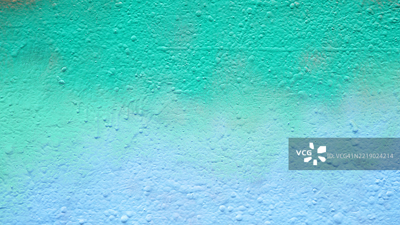 水泥墙上的绿色和蓝色油漆特写。粗糙的纹理。阳光。自然色彩。法国巴黎。全画幅 4:3图片素材