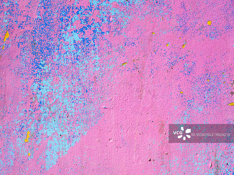 水泥墙上风化和剥落的粉色、蓝色和黄色油漆。粗糙的纹理。全画幅 4:3。阳光。自然色彩。法国巴黎。图片素材