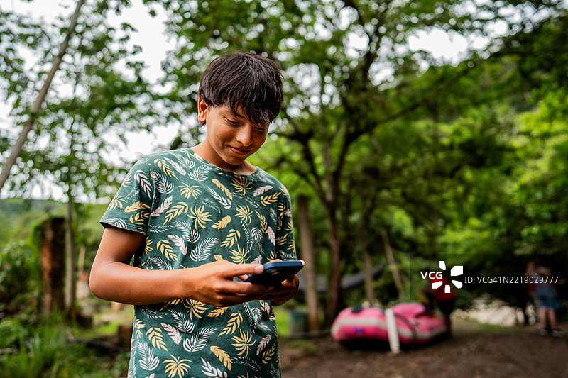 户外使用手机的少年男孩图片素材