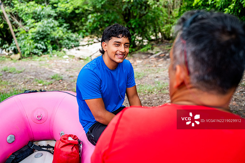 年轻人和父亲在白水漂流前交谈图片素材