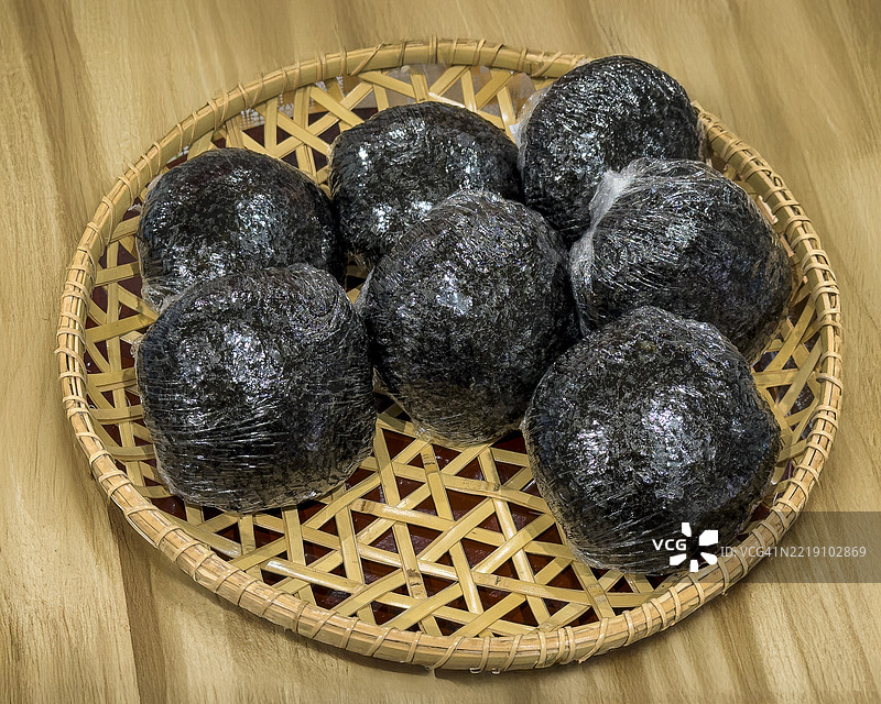 自制的饭团用塑料包裹，放在竹制托盘上图片素材