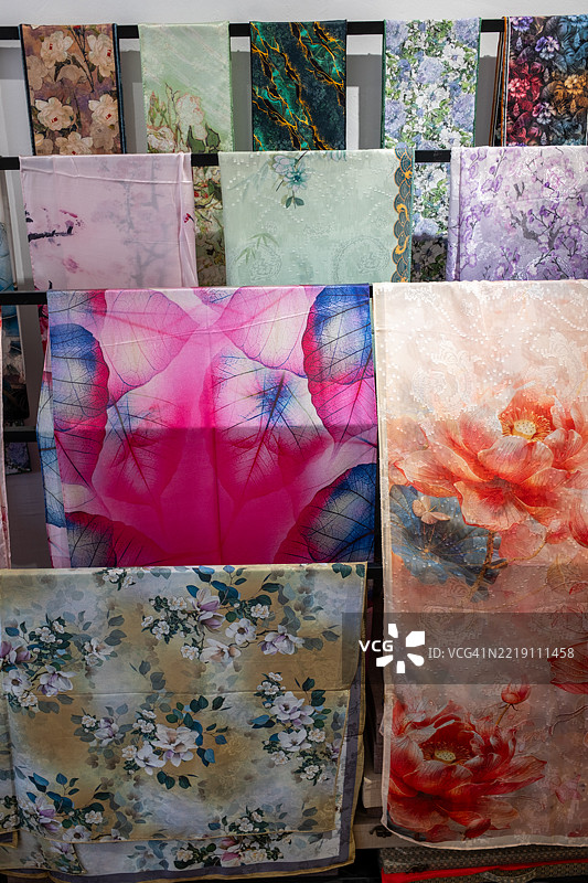 五彩缤纷的花卉和抽象面料印花展示在架子上图片素材
