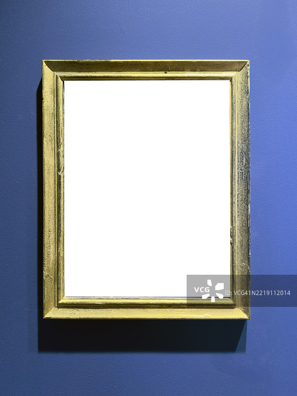 空的古董金色框架挂在蓝色墙壁上图片素材