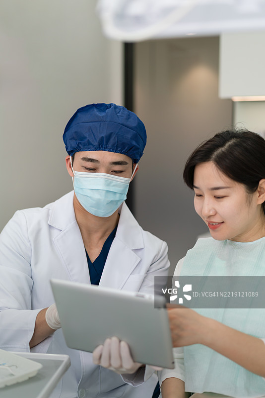牙医在牙科诊所咨询手术数据。图片素材