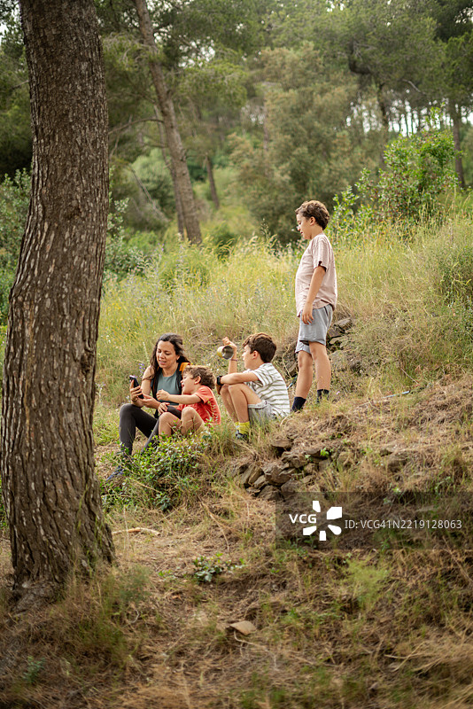 母亲和儿子们在徒步旅行中休息图片素材