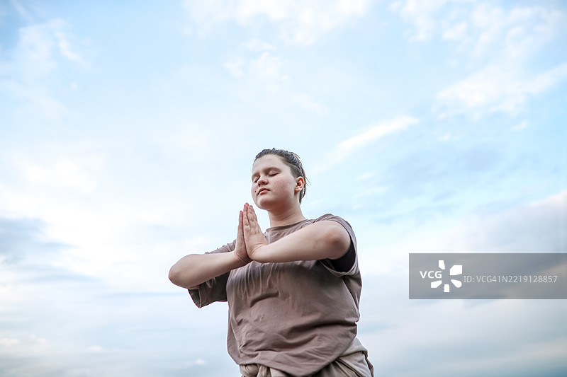 在天空下，胖女孩通过冥想探索世界和自我图片素材