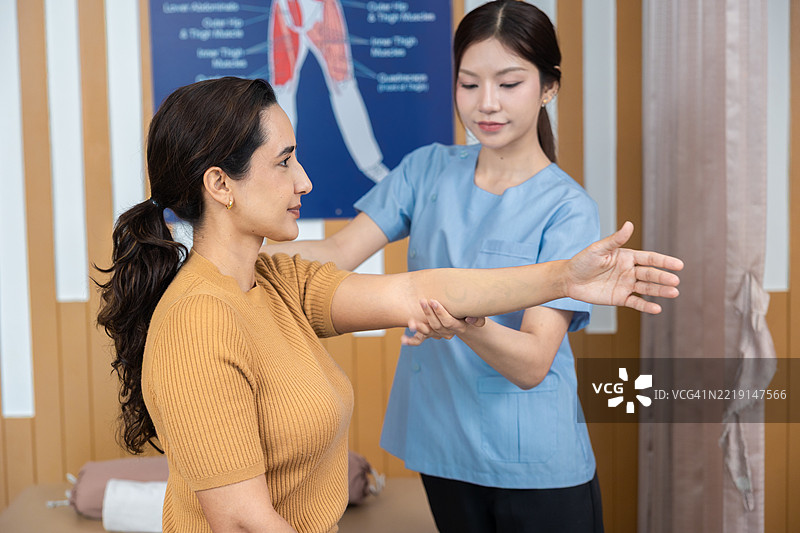 物理治疗师与患者合作。上肢被动运动练习。医生咨询患者的手臂问题，物理治疗概念。竖版视频。图片素材