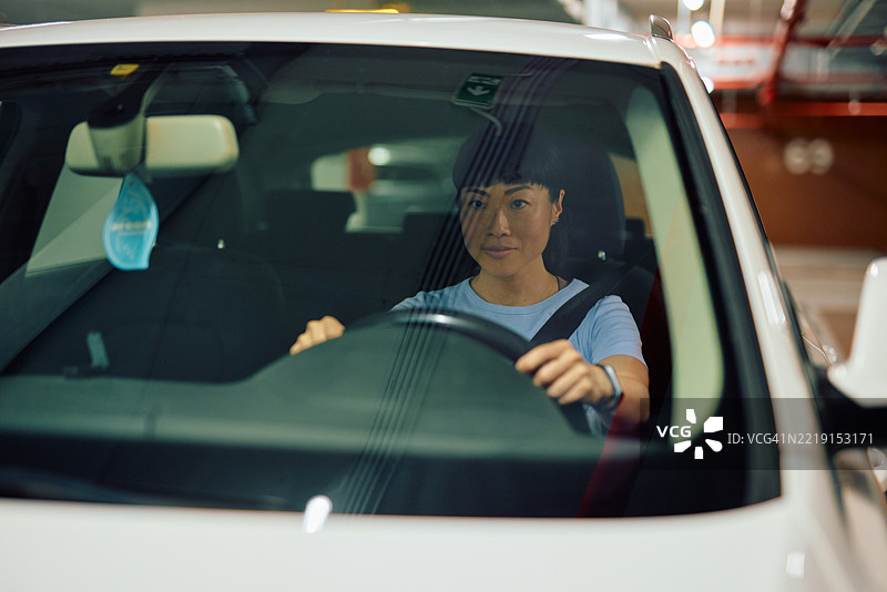 亚洲女性在停车场开车并看向镜头图片素材