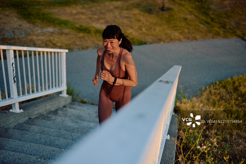 坚定的亚洲女性在户外锻炼时跑上楼梯图片素材