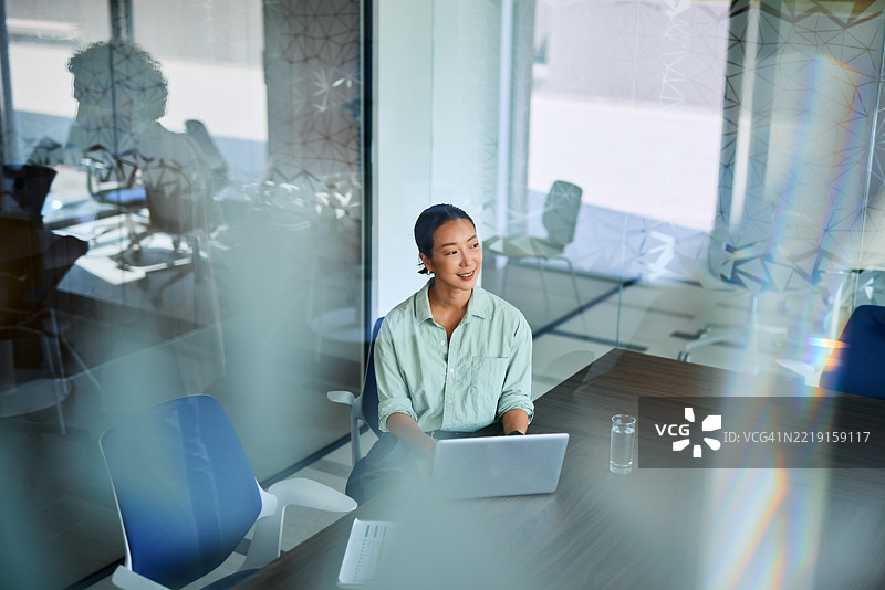 年轻的亚洲女商人在现代办公室使用笔记本电脑工作图片素材