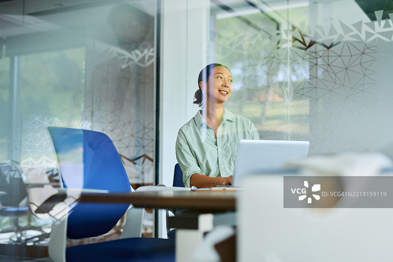 年轻的亚洲女商人在现代办公室使用笔记本电脑工作图片素材