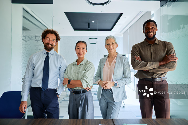 自信的商业团队在现代办公室微笑并交叉双臂图片素材