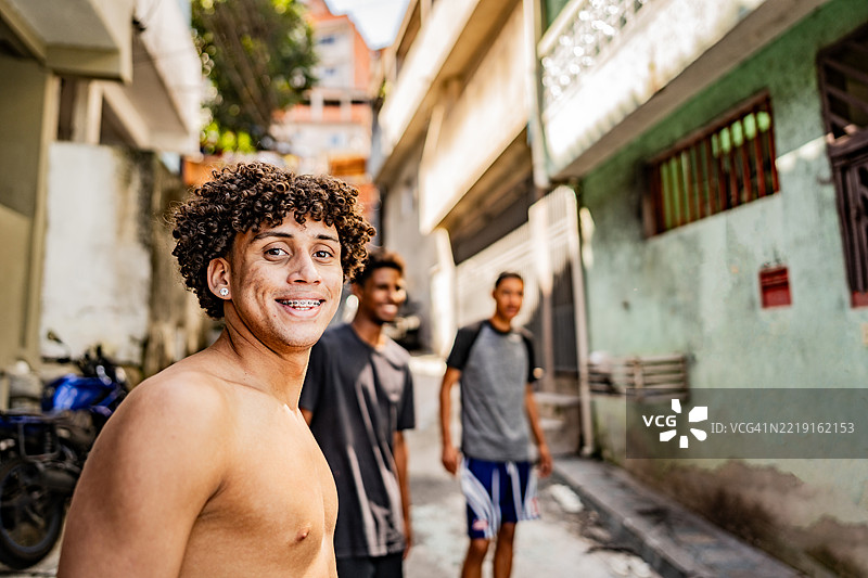 年轻的巴西男子与朋友们在巴西的贫民区微笑图片素材