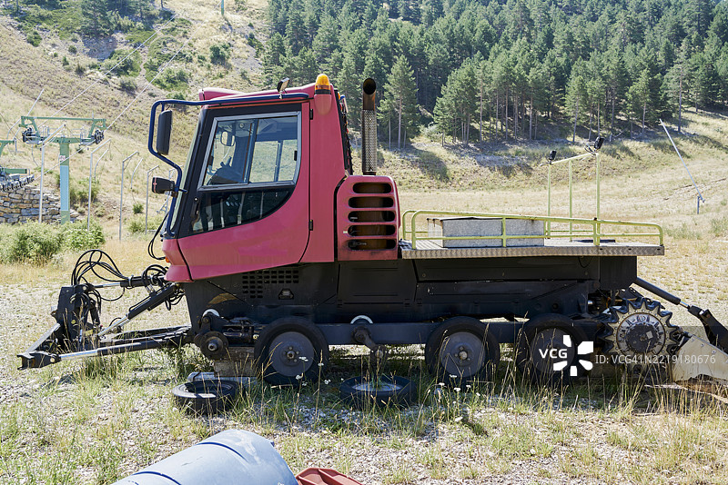 夏季时停放在滑雪缆车附近的红色雪地压雪机图片素材