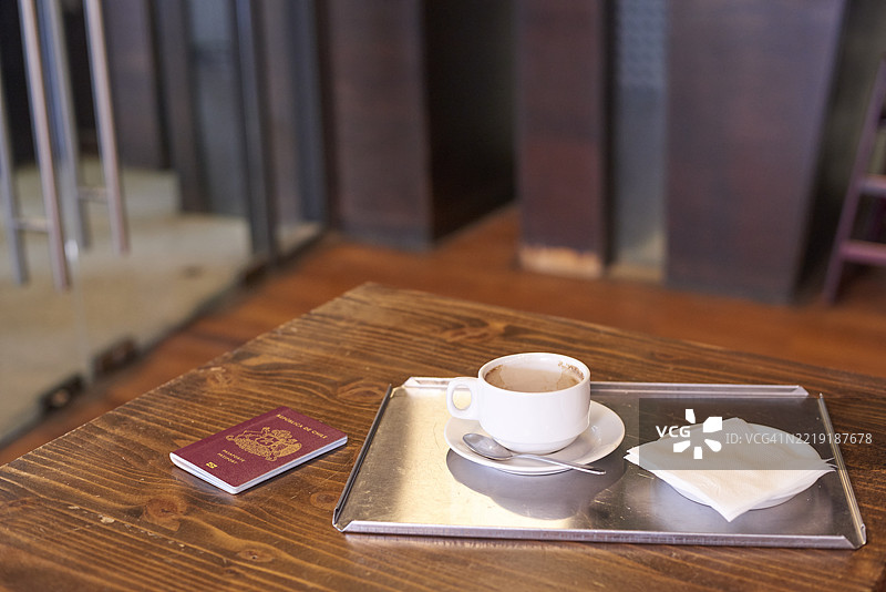 智利护照和咖啡杯静静地放在咖啡馆的桌子上图片素材