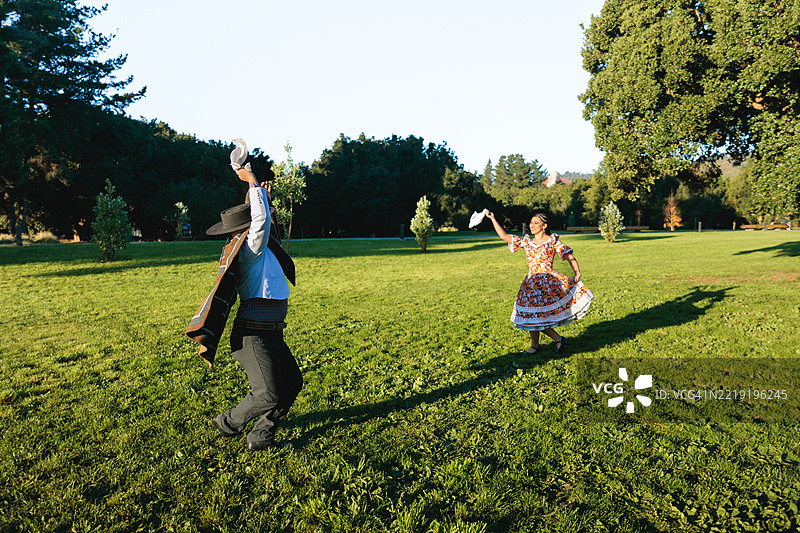 智利的华索和华萨在阳光明媚的草地上跳库埃卡舞图片素材