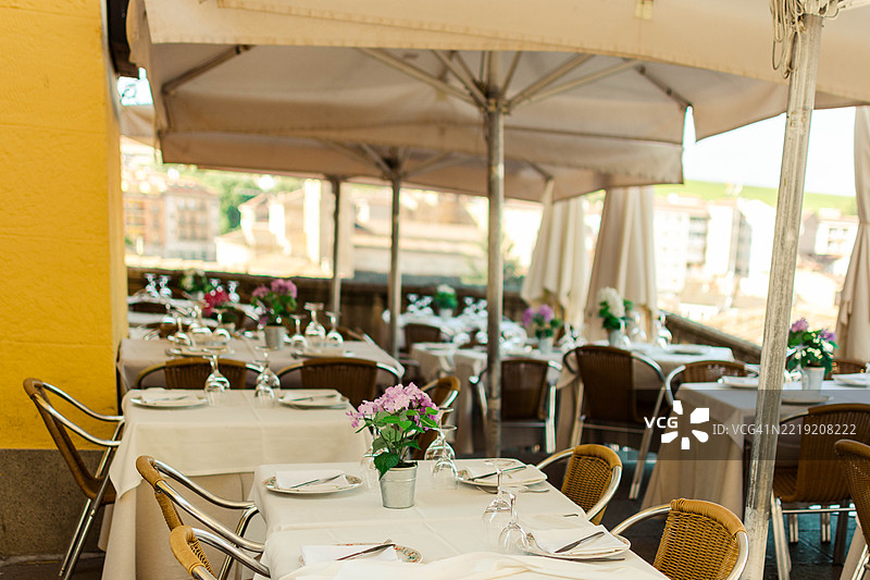 户外餐厅桌子摆放好，准备享用午餐，背景是城市景观图片素材